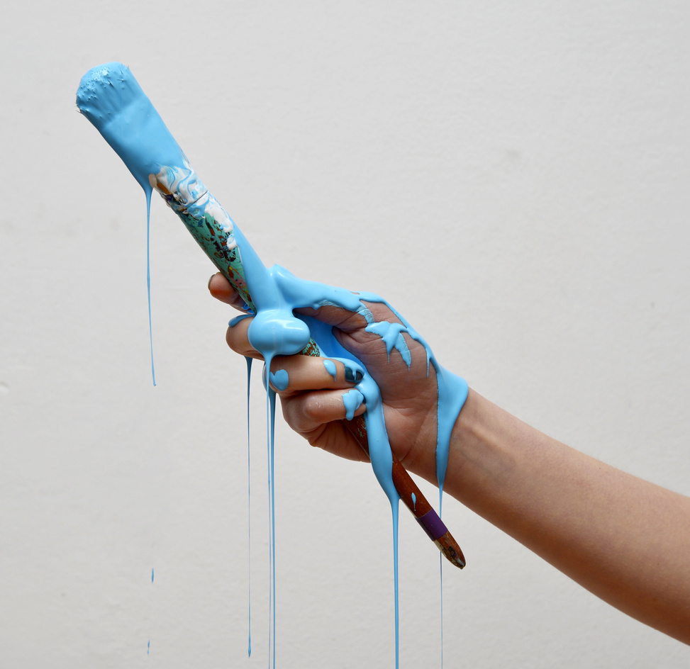 Hand Holding a Paintbrush with Blue Paint